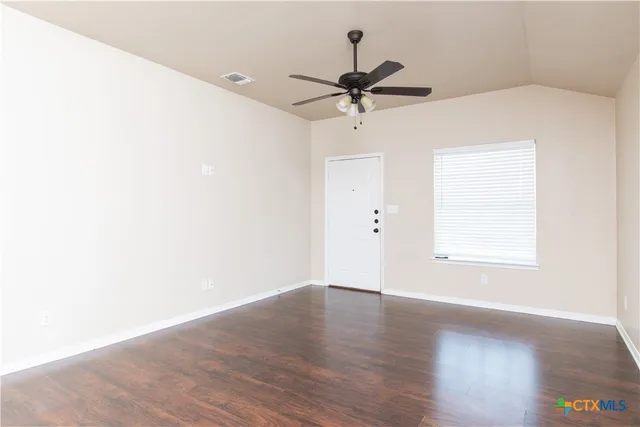a view of a big room with wooden floor closet and windows