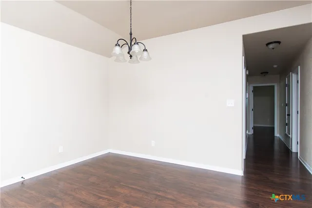 a view of a room with wooden floor and ceiling fan