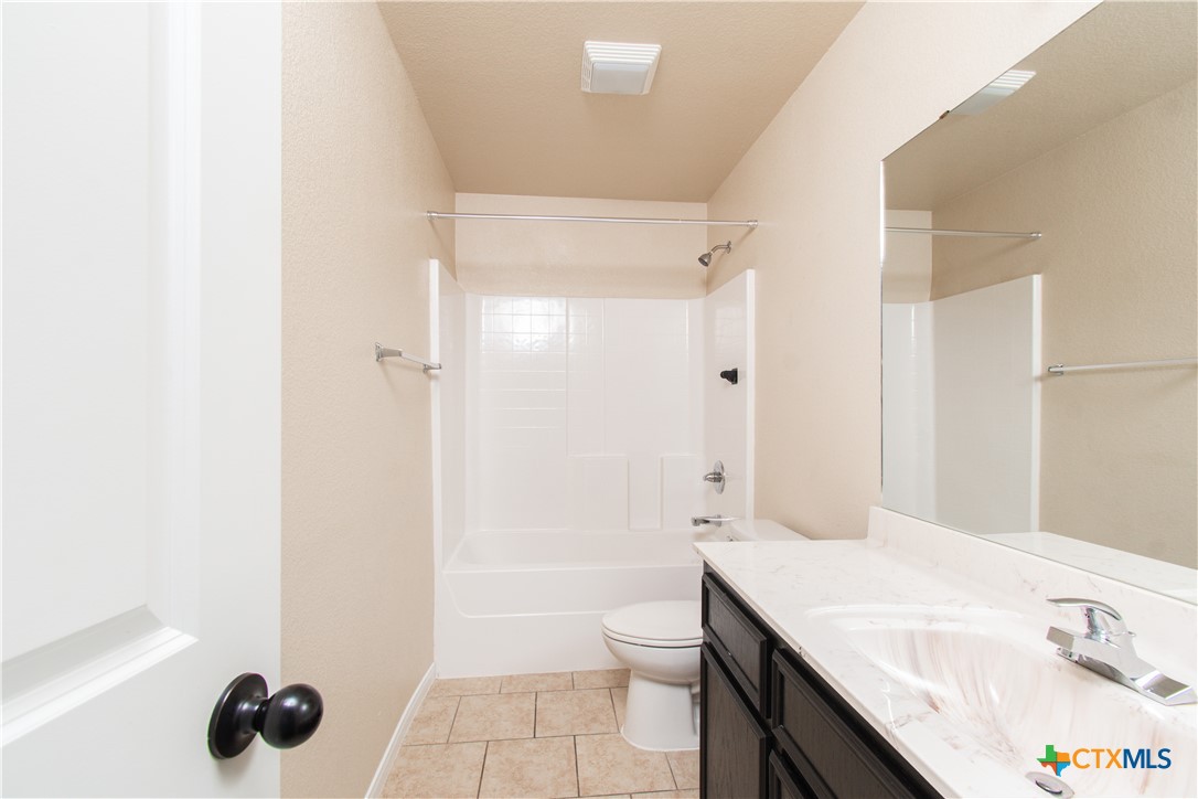 1102 Grace Point Drive, Unit A Killeen, TX 76549 - Photo 10 of 18 a bathroom with a granite countertop sink a toilet and shower