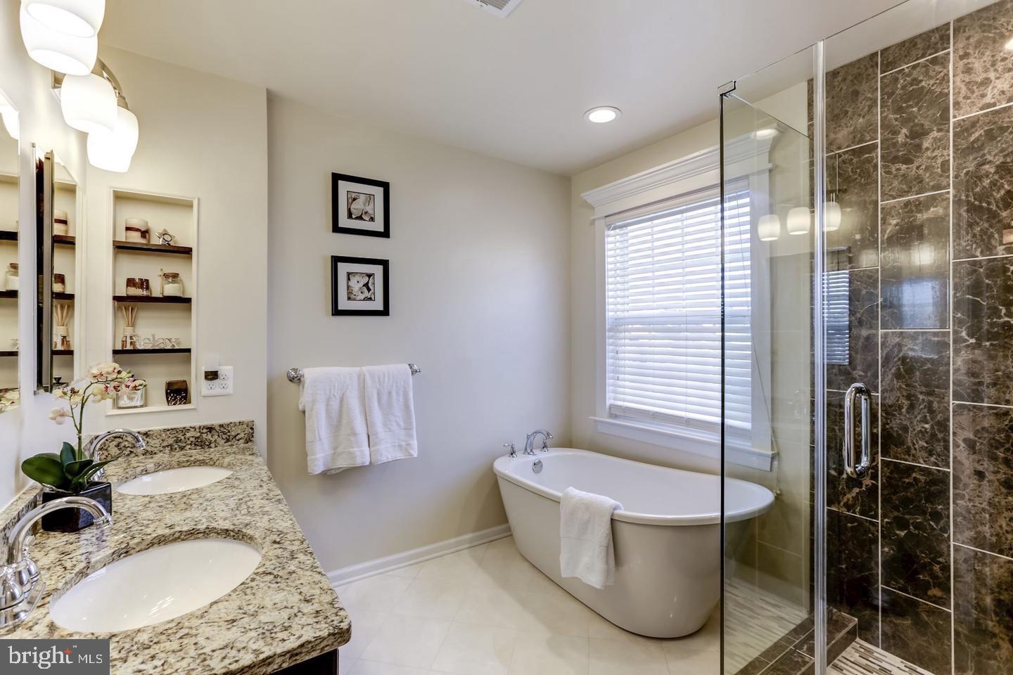 10106 Sir Reynard Lane Bristow, VA 20136 - Photo 14 of 28 a bathroom with a granite countertop bathtub a sink and a shower