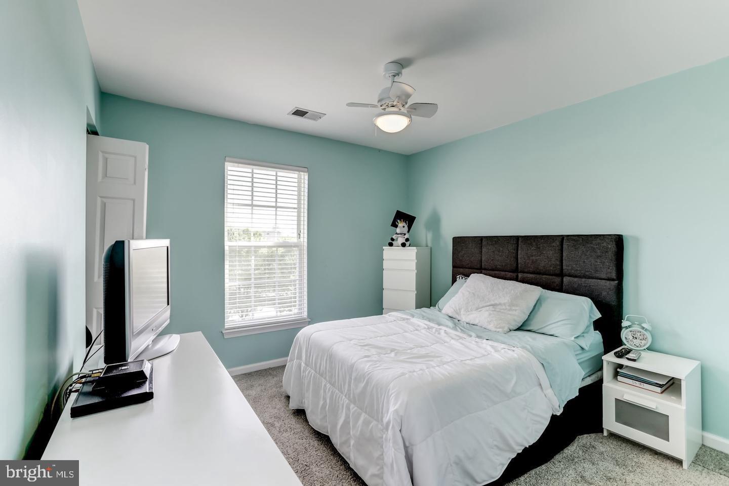 10106 Sir Reynard Lane Bristow, VA 20136 - Photo 16 of 28 a bedroom with a large bed and a flat tv screen on a dresser