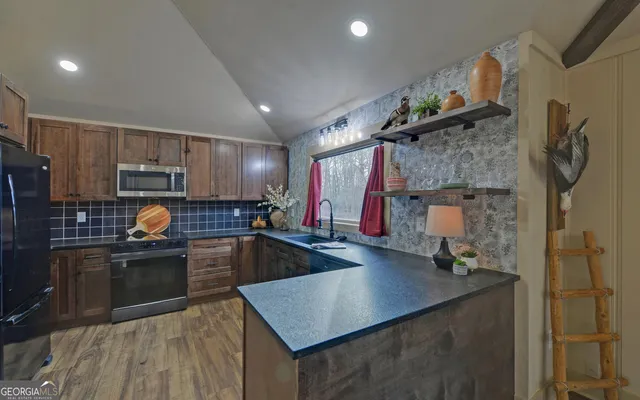a kitchen with kitchen island granite countertop a sink counter top space appliances and cabinets
