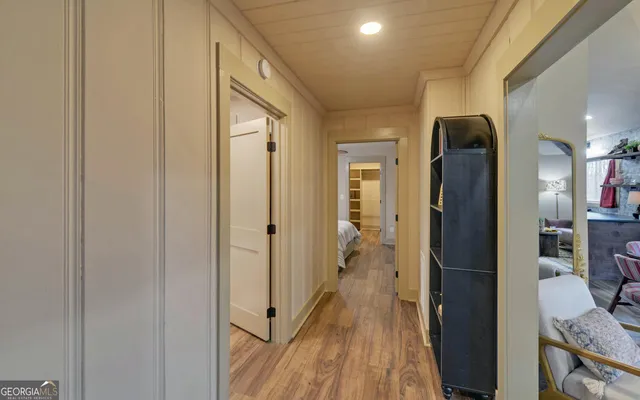 a view of hallway with livingroom and wooden floor