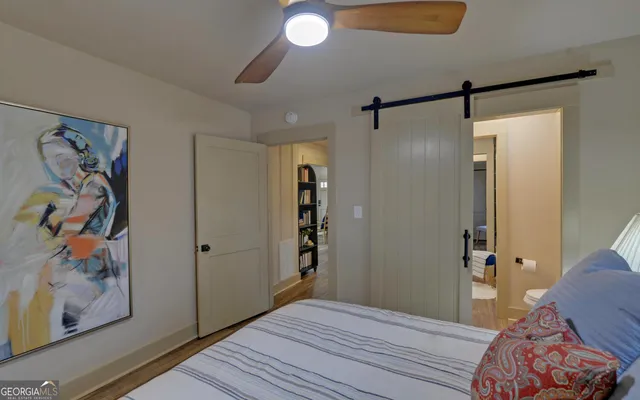 a bedroom with a bed and a painting on the wall