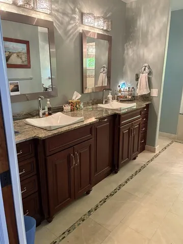 a bathroom with a granite countertop sink a large mirror and a