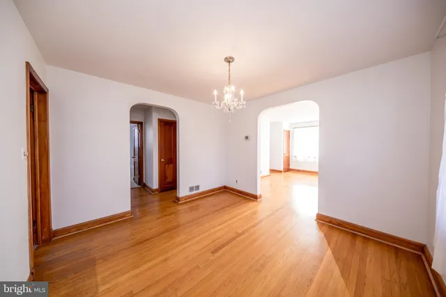 a view of a room with wooden floor and chandelier