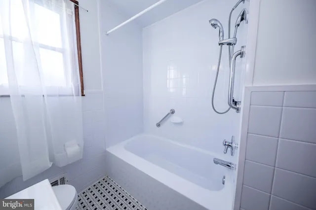 a bathroom with a bathtub a toilet and a shower