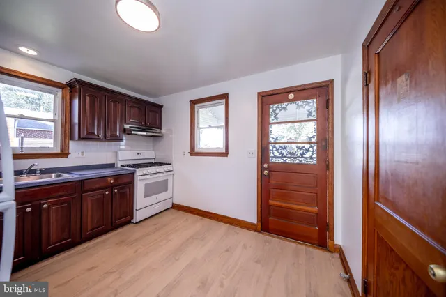 a kitchen with granite countertop wooden cabinets and white appliances