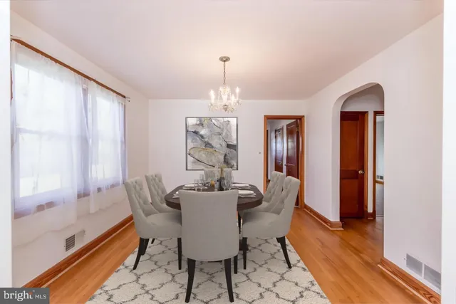 a dining room with furniture a chandelier and wooden floor