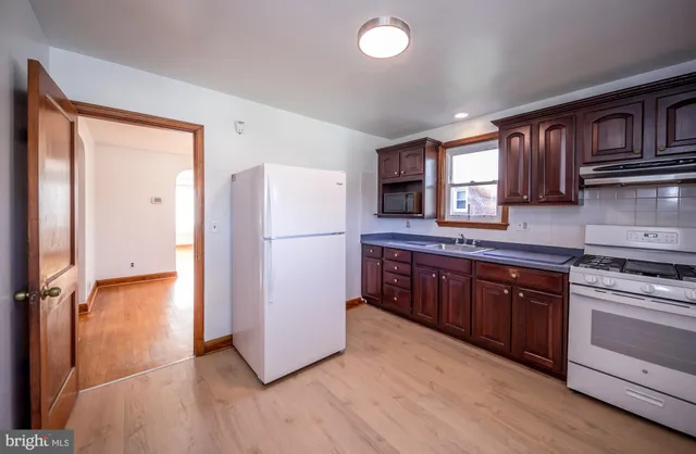 a kitchen with stainless steel appliances granite countertop a refrigerator a stove a sink and a microwave