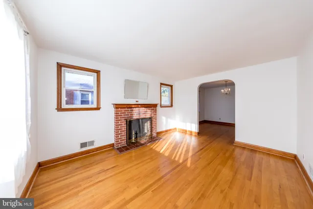 a view of empty room with wooden floor and fireplace