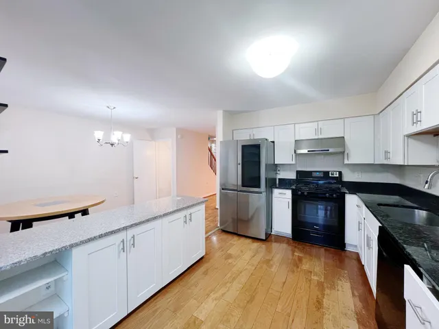 a kitchen with granite countertop a sink stove and refrigerator