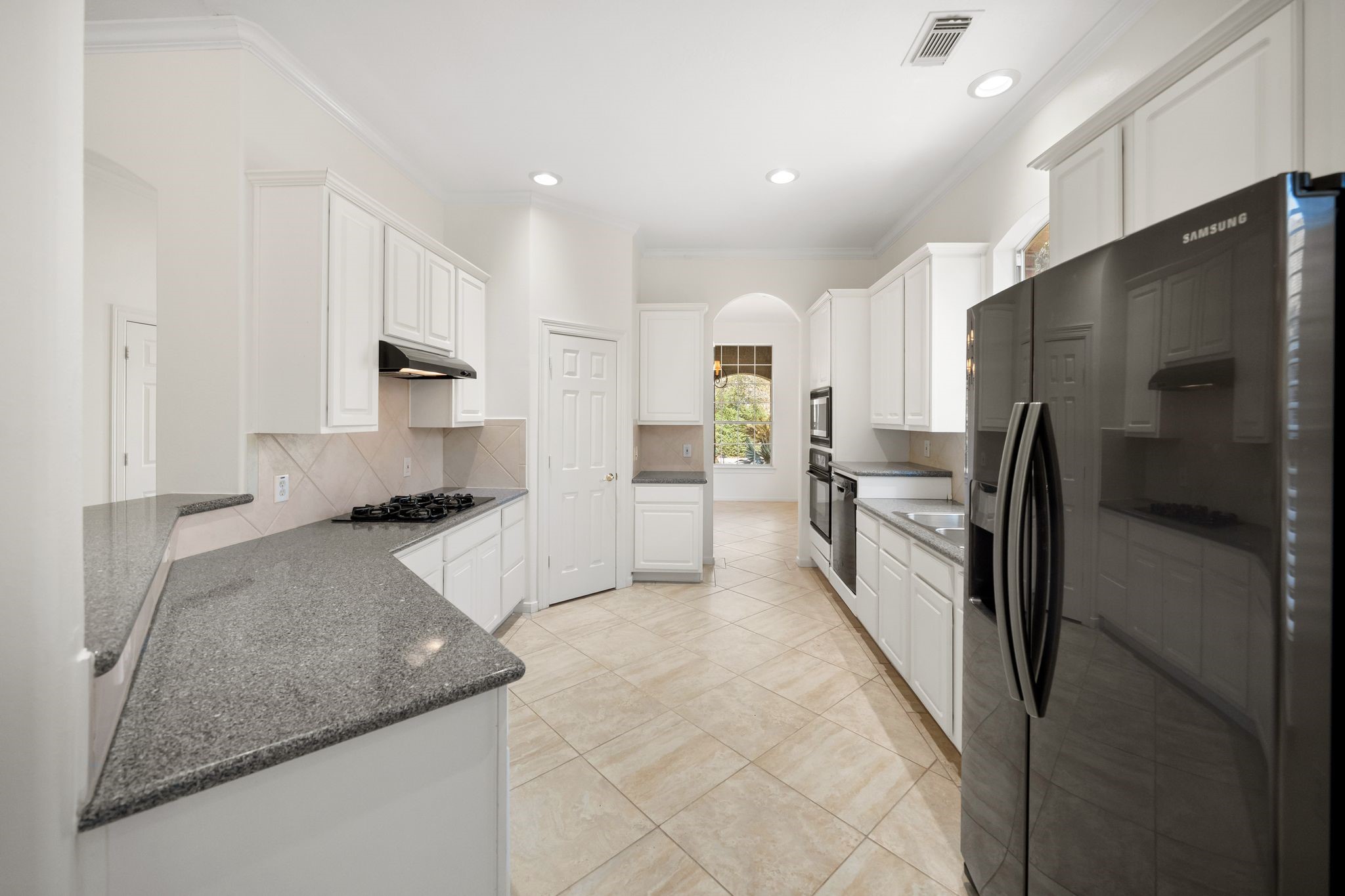 7 Sovereign Way Conroe, TX 77384 - Photo 7 of 31 a kitchen with stainless steel appliances granite countertop a refrigerator a stove and a sink with wooden cabinets