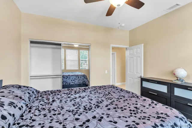a living room with furniture a chandelier fan and a kitchen view