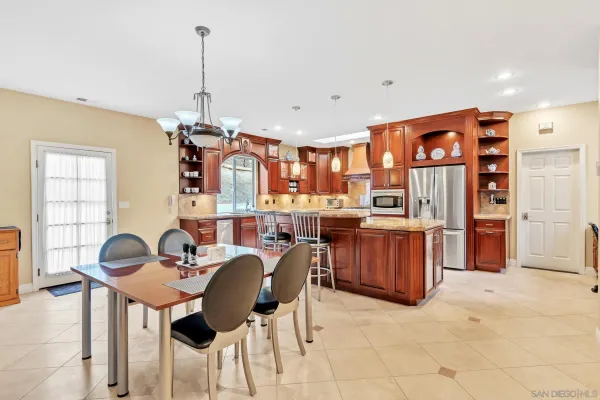 a kitchen with stainless steel appliances granite countertop a stove a sink dishwasher and a refrigerator with wooden cabinets