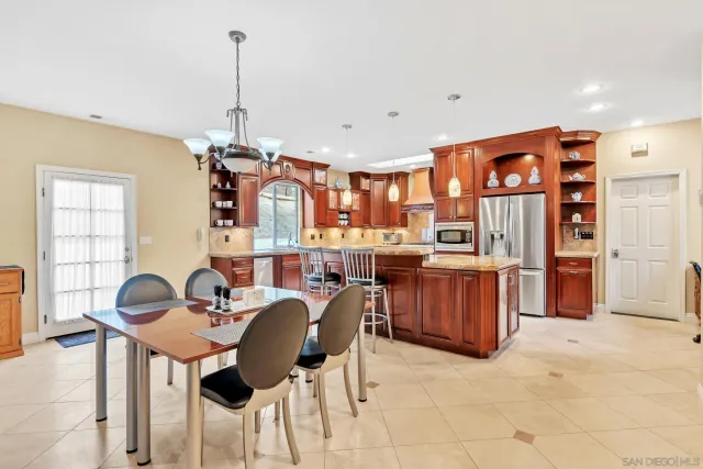 a kitchen with stainless steel appliances granite countertop a stove a sink dishwasher and a refrigerator with wooden cabinets