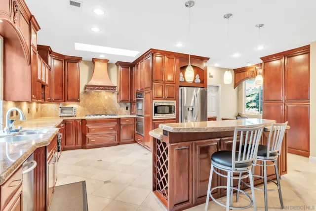 a kitchen with stainless steel appliances granite countertop a refrigerator and a stove top oven