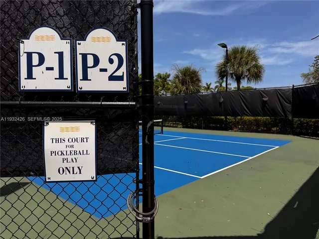 a view of a tennis court with a house in the background