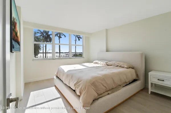 a large bed sitting in a bedroom next to a window