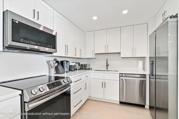 a kitchen with stainless steel appliances white cabinets and a stove top oven