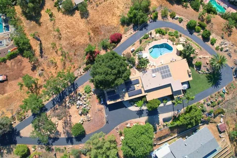 an aerial view of a house with a yard and outdoor seating