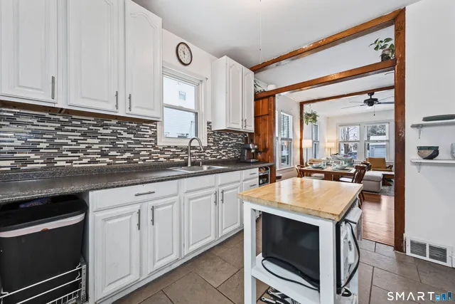 a kitchen with granite countertop white cabinets and stainless steel appliances