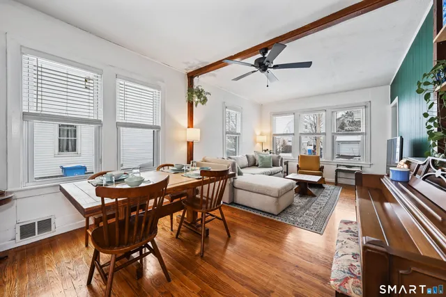 a view of a livingroom and dining room and wooden floor