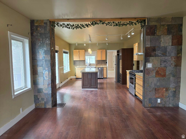 250 South Main Street Fillmore, UT 84631 - Photo 3 of 12 Kitchen with dark wood-style flooring, stainless steel appliances, a kitchen island, light stone counters, and tasteful backsplash