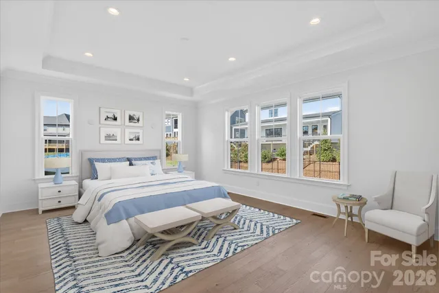 a spacious bedroom with a bed a couch and a large window