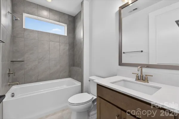 a bathroom with a granite countertop sink a toilet and bathtub