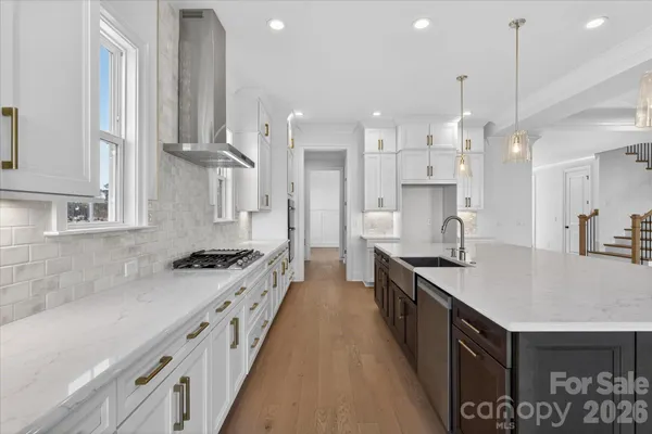 a large kitchen with stainless steel appliances granite countertop a lot of counter space and wooden floor