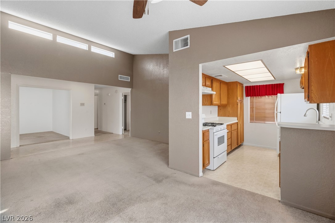 2124 Pebble Creek Lane Laughlin, NV 89029 - Photo 54 of 54 Kitchen with light countertops, white appliances, a ceiling fan, light colored carpet, and open floor plan