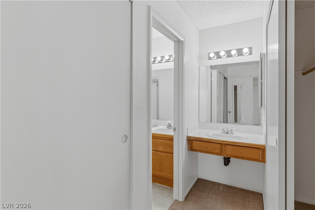 2124 Pebble Creek Lane Laughlin, NV 89029 - Photo 23 of 54 Primary ensuite Bathroom featuring a textured ceiling and vanity