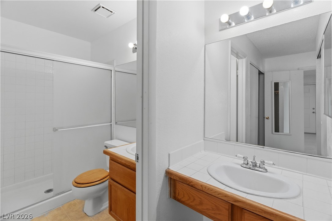 2124 Pebble Creek Lane Laughlin, NV 89029 - Photo 24 of 54 Full Primary ensuite bathroom featuring vanity, a stall shower, and light tile patterned flooring