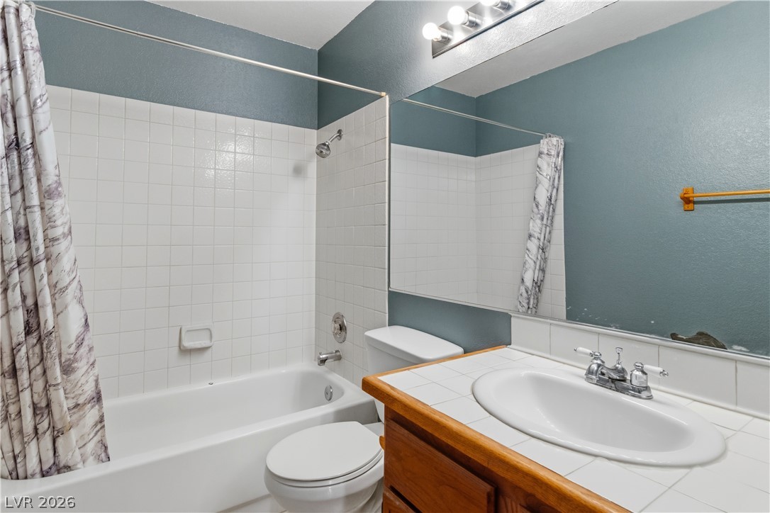2124 Pebble Creek Lane Laughlin, NV 89029 - Photo 28 of 54 Full hall bath featuring a textured wall, vanity, and shower / tub combo with curtain