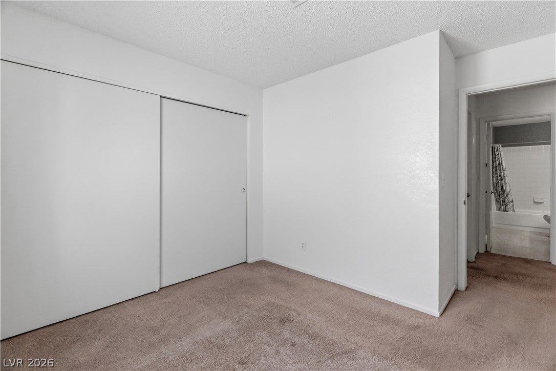 2124 Pebble Creek Lane Laughlin, NV 89029 - Photo 29 of 54 Third bedroom featuring light colored carpet, a textured ceiling, and a closet
