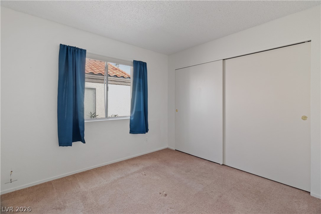 2124 Pebble Creek Lane Laughlin, NV 89029 - Photo 30 of 54 Third bedroom with a textured ceiling, light carpet, and a closet