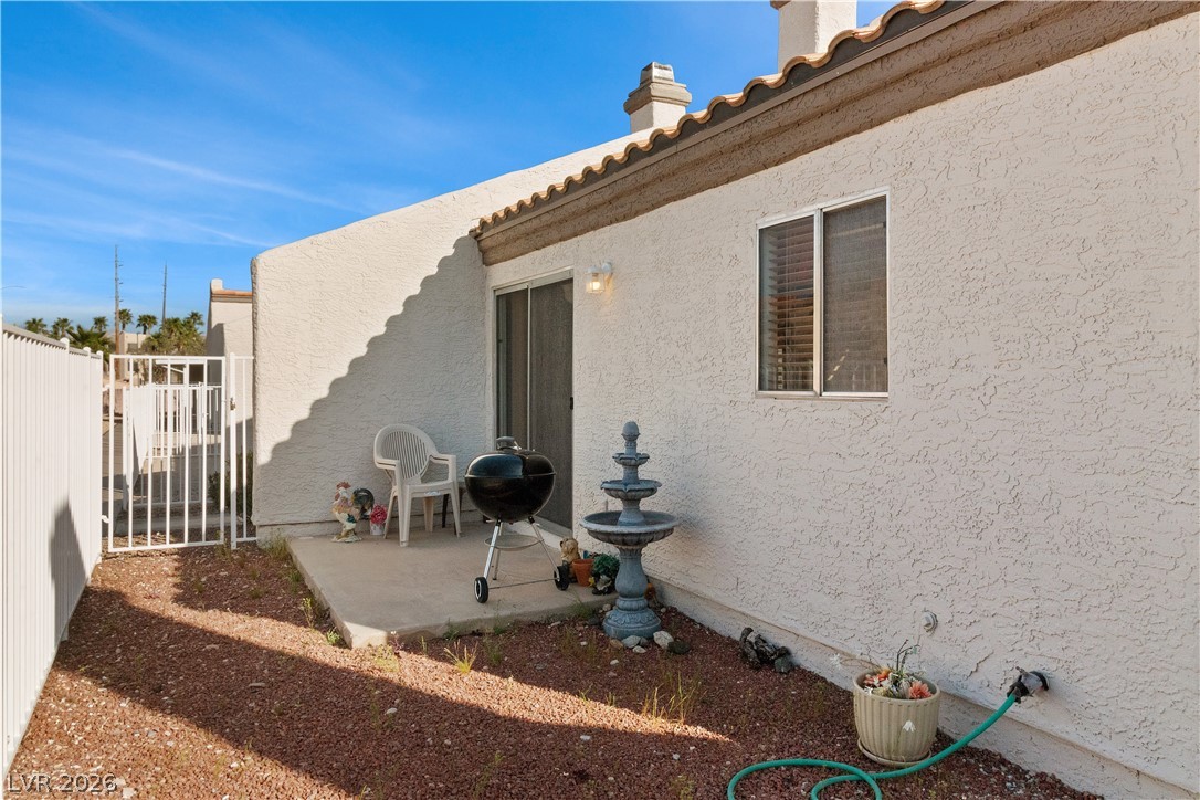 2124 Pebble Creek Lane Laughlin, NV 89029 - Photo 39 of 54 Back of house with a patio area, stucco siding, a gate, a tiled roof, and a chimney