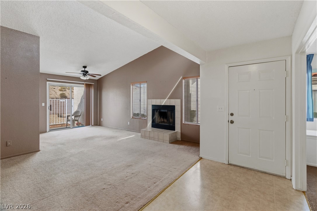 2124 Pebble Creek Lane Laughlin, NV 89029 - Photo 4 of 54 living room with ceiling fan, a fireplace, light colored carpet, and light floors