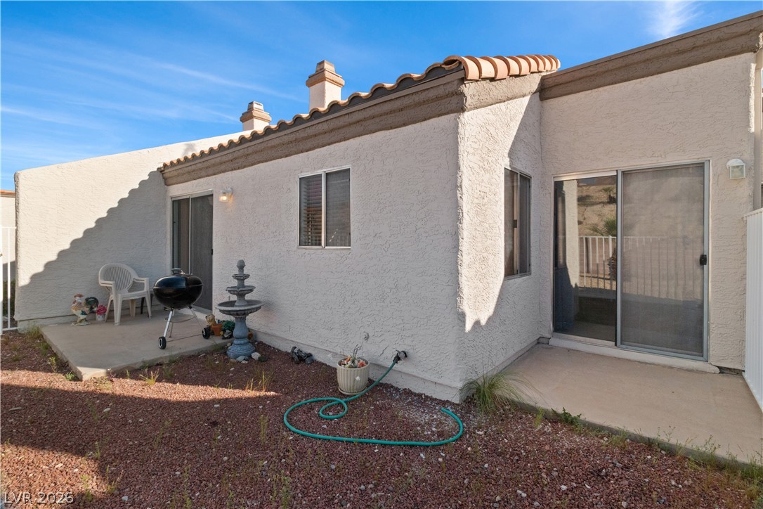 2124 Pebble Creek Lane Laughlin, NV 89029 - Photo 40 of 54 Rear view of house with a patio, stucco siding, a chimney, and a tiled roof