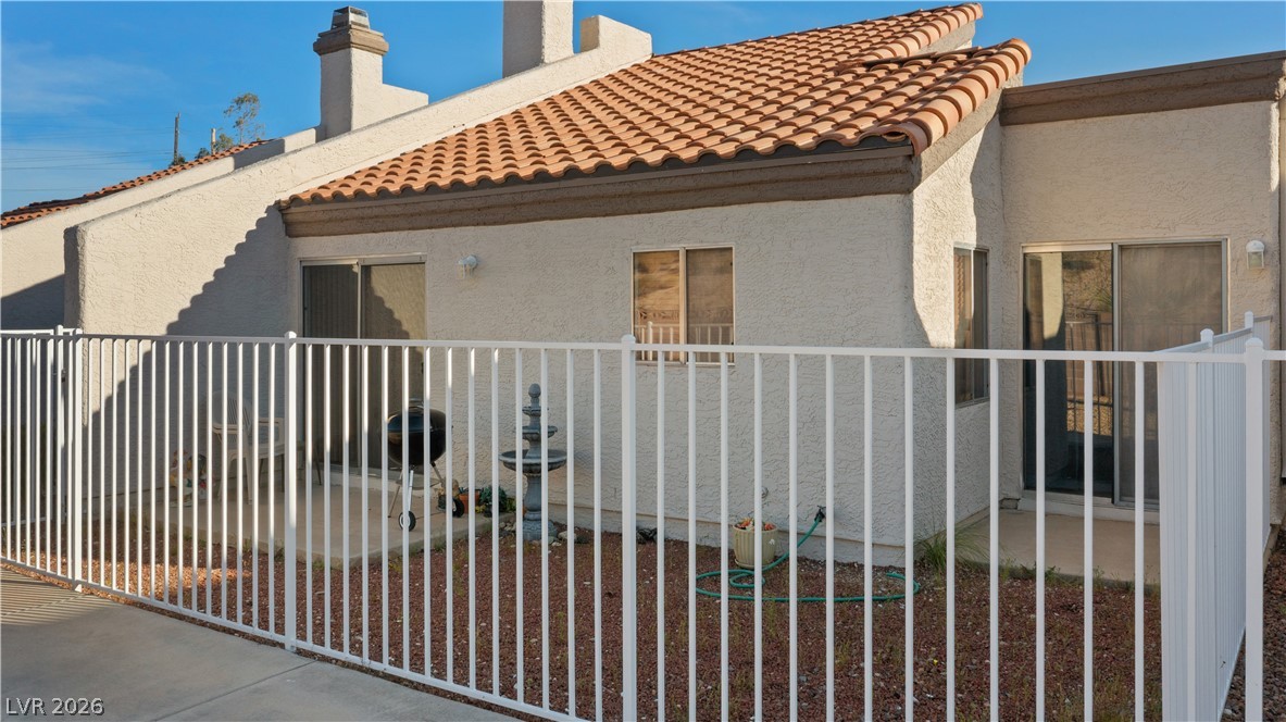 2124 Pebble Creek Lane Laughlin, NV 89029 - Photo 46 of 54 Back of property with stucco siding, a tiled roof, and a chimney