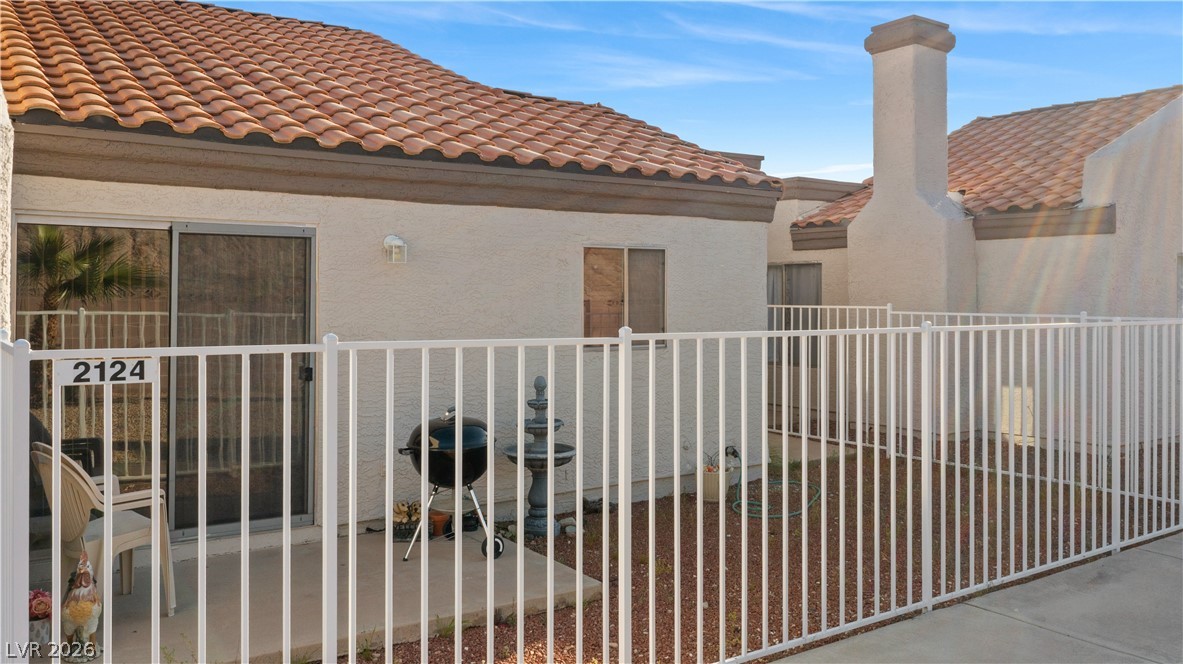 2124 Pebble Creek Lane Laughlin, NV 89029 - Photo 47 of 54 Back of property with stucco siding, a tiled roof, and a chimney