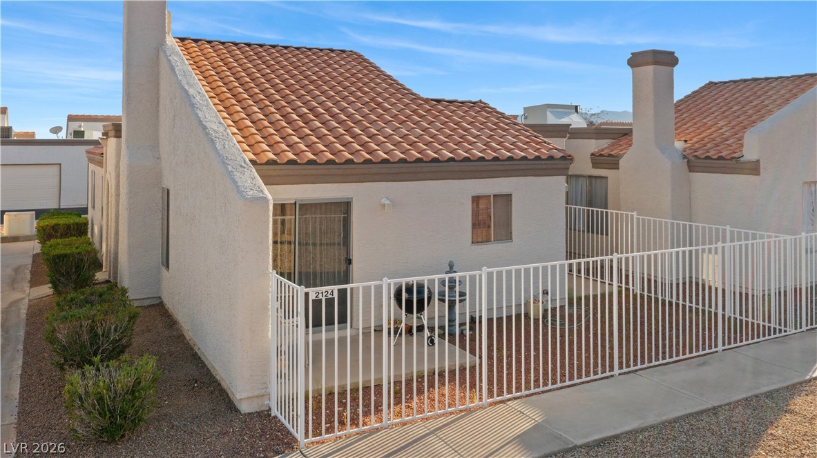 2124 Pebble Creek Lane Laughlin, NV 89029 - Photo 48 of 54 Back of house featuring a tiled roof, stucco siding, and a chimney