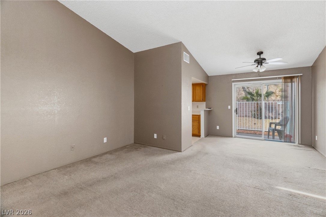 2124 Pebble Creek Lane Laughlin, NV 89029 - Photo 7 of 54 Living room with a ceiling fan, lofted ceiling, and light carpet
