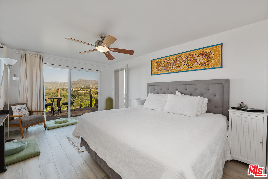 29500 Heathercliff Road, Unit 202 Malibu, CA 90265 - Photo 20 of 36 a bedroom with a bed and wooden floor