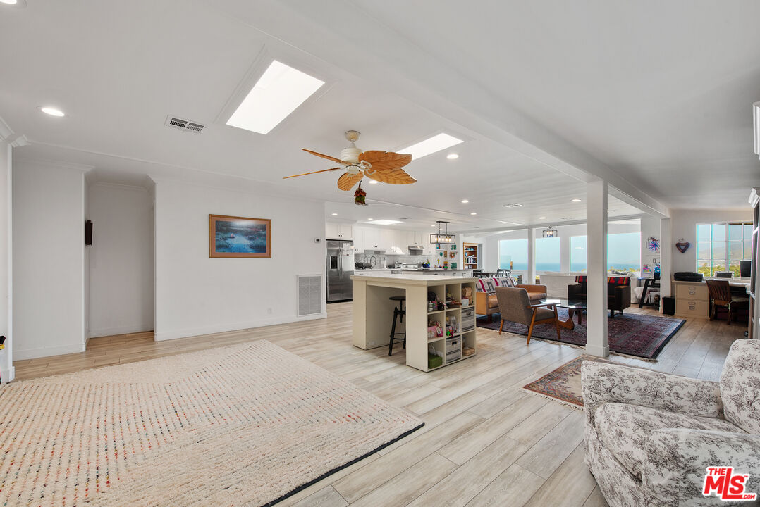 29500 Heathercliff Road, Unit 202 Malibu, CA 90265 - Photo 6 of 36 a living room with furniture a dining table and chairs with kitchen view