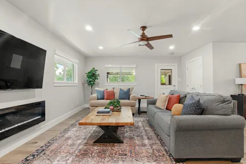 a living room with furniture a flat screen tv and a fireplace