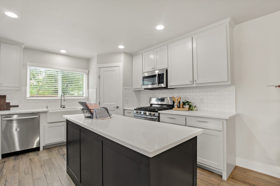 9110 Chisholm Lane Austin, TX 78748 - Photo 8 of 27 a kitchen with a sink stove a sink a refrigerator and cabinets