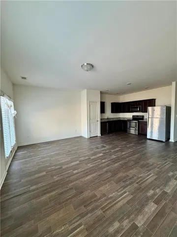 a view of empty room with wooden floor and window