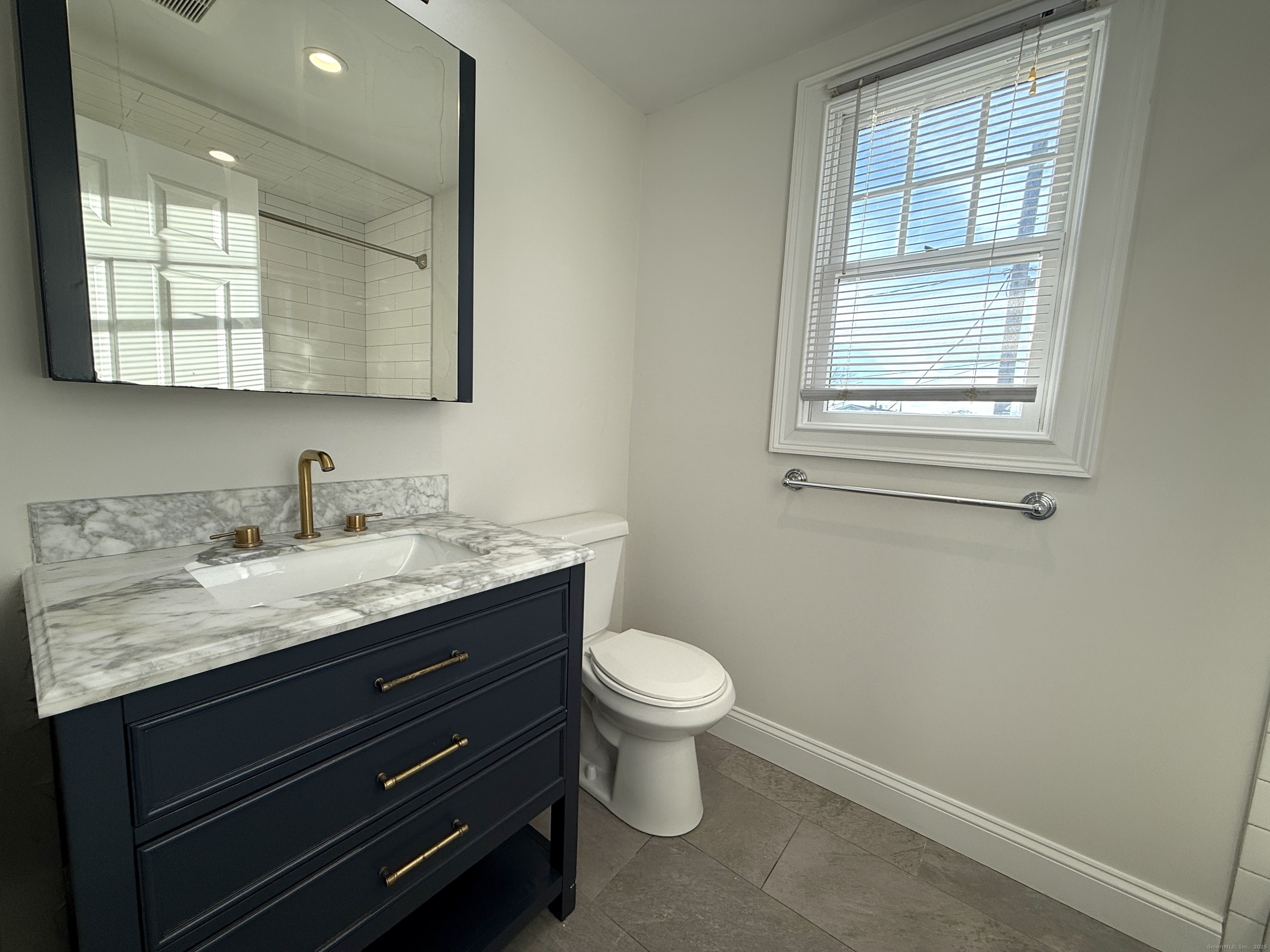 5 Myrtle Street Norwalk, CT 06855 - Photo 6 of 15 a bathroom with a granite countertop toilet sink and mirror